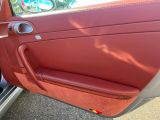 une portière de voiture rouge dont la poignée est ouverte