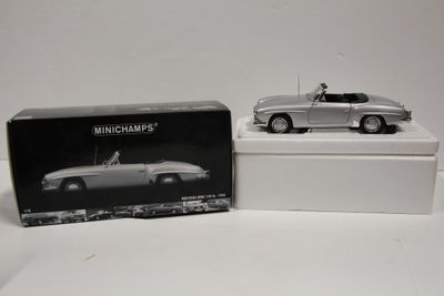 une boîte contenant une maquette argentée d'une voiture de sport et une boîte avec une photo en noir et blanc d'une voiture de sport