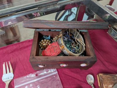 une petite boîte en bois contenant un assortiment de bijoux