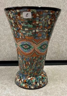 un vase posé sur une table, sur lequel est accrochée une étiquette