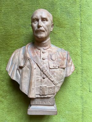 statue of a man in a military uniform on a green wall