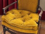 une chaise jaune placée devant un rideau rouge