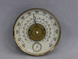 une horloge accrochée au mur et équipée d'un thermomètre