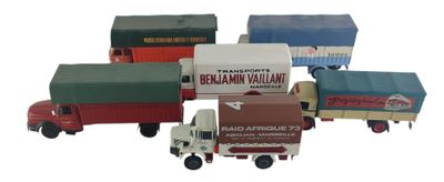 plusieurs camions jouets sont alignés sur une surface blanche