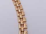 an image of a close up of a gold bracelet on a white surface
