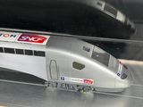 a model of a silver train on display in a glass case