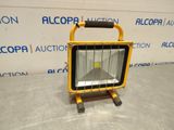 un projecteur jaune posé sur une table en métal