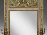un miroir richement décoré, doté d'un cadre doré et de deux chérubins