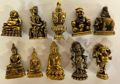 brass figurines of buddhas are displayed on a white surface