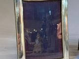 pair of silver plated picture frames with a picture of a man and a woman