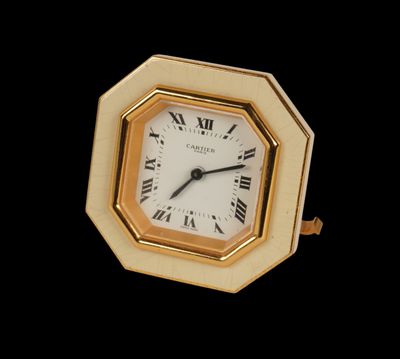 a small clock with roman numerals on the face