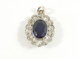 un gros plan d'un pendentif en saphir et diamants sur fond blanc