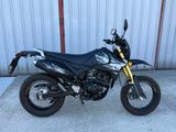 une photo d'une moto garée devant un immeuble