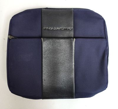 le dos d'un sac bleu et noir posé sur une surface blanche