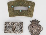 trois pièces de métal et de verre sont exposées sur une surface blanche