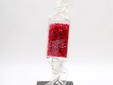 sculpture of a red bag of candy on a black base