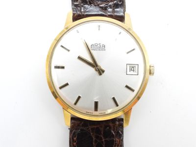 une image d'un gros plan d'une montre-bracelet sur une surface blanche