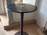a black table with a candle on it in the middle of a room