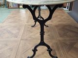a table with a marble top sitting on a wooden floor