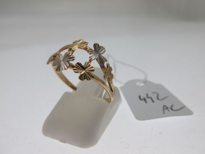 un gros plan d'une bague en or ornée de fleurs