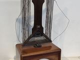 une boîte en bois surmontée d'une sculpture en fil de fer