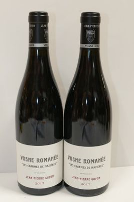 deux bouteilles de vin posées sur une table l'une à côté de l'autre