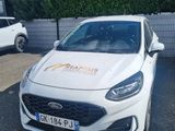une voiture blanche garée sur un parking près d'une clôture