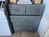 a grey chest of drawers in a kitchen with a laptop on top of it