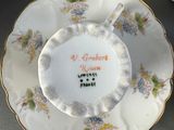 a plate with a flower design on it and a cup and saucer
