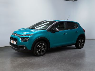 a blue car parked in a garage next to a white wall