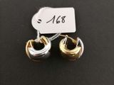a pair of gold and silver earrings on a black surface