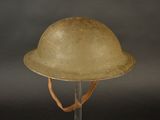 an old military helmet on a stand against a black background
