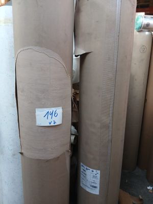 Plusieurs rouleaux de papier sont empilés les uns sur les autres dans un entrepôt