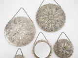trois miroirs en métal argenté et un miroir accroché au mur
