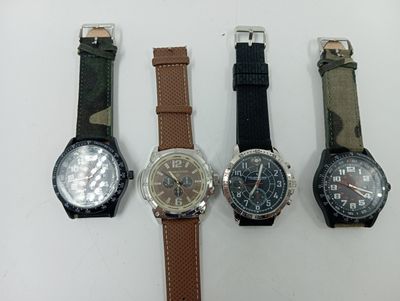 quatre montres différentes sont alignées sur une surface blanche