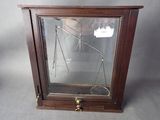 une vitrine en verre sur laquelle est posée une balance, posée sur une table