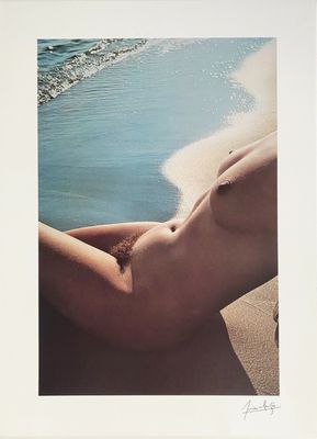 an image of a nude woman laying on a beach next to the ocean