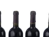 three bottles of wine are lined up in a row on a white surface