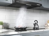 une photo d'une cuisine avec une plaque de cuisson et une bouilloire posée dessus