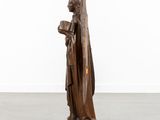 a wooden statue of a man holding a book in his hands