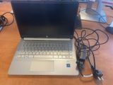 a laptop that is sitting on a table with a charger
