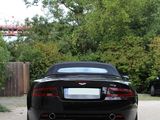 a black sports car parked in a driveway next to a wooden fence