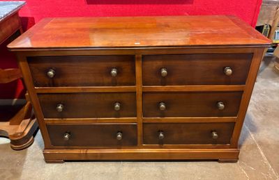 une commode en bois dans une pièce aux murs rouges