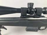 the rifle is sitting on the table with a scope on it