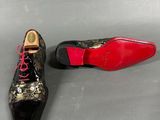 two pairs of black and gold shoes with red laces