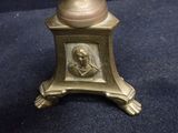 a gold vase that has a picture of a woman on it