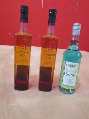 trois bouteilles d'alcool posées les unes à côté des autres sur une table
