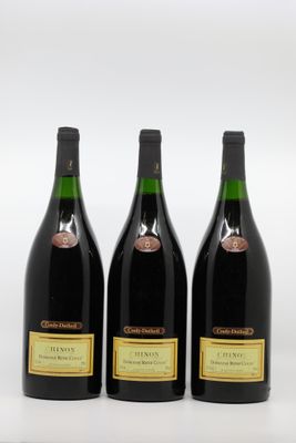 three bottles of wine are lined up on a white surface