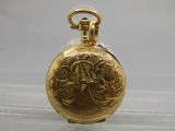 a gold pocket watch with a chain on a table
