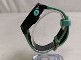 a green and black watch sitting on a clear stand